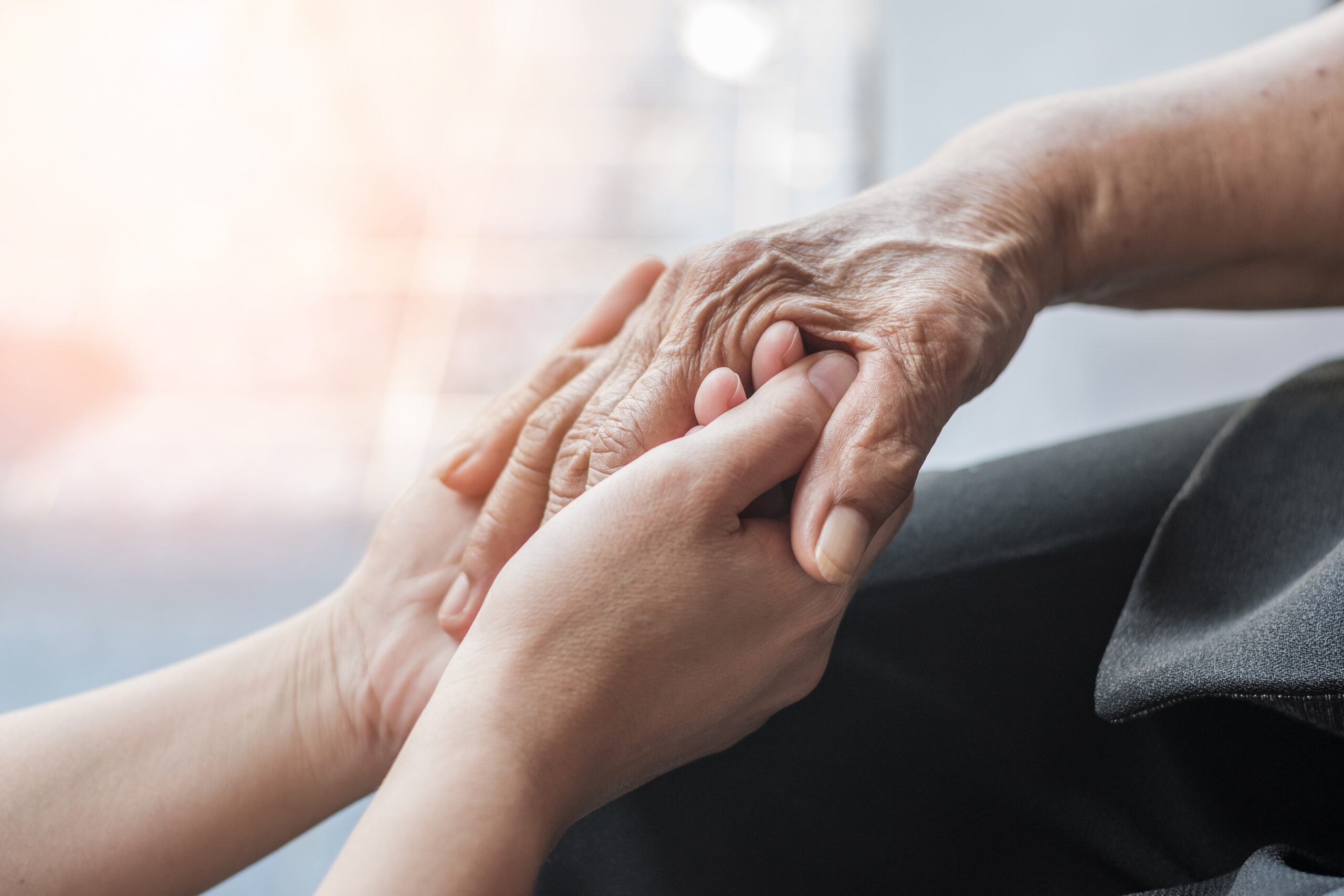 Caregiver supporting a senior’s hand, representing BoldBids Houston senior transitions, estate sale support, and probate‑related services